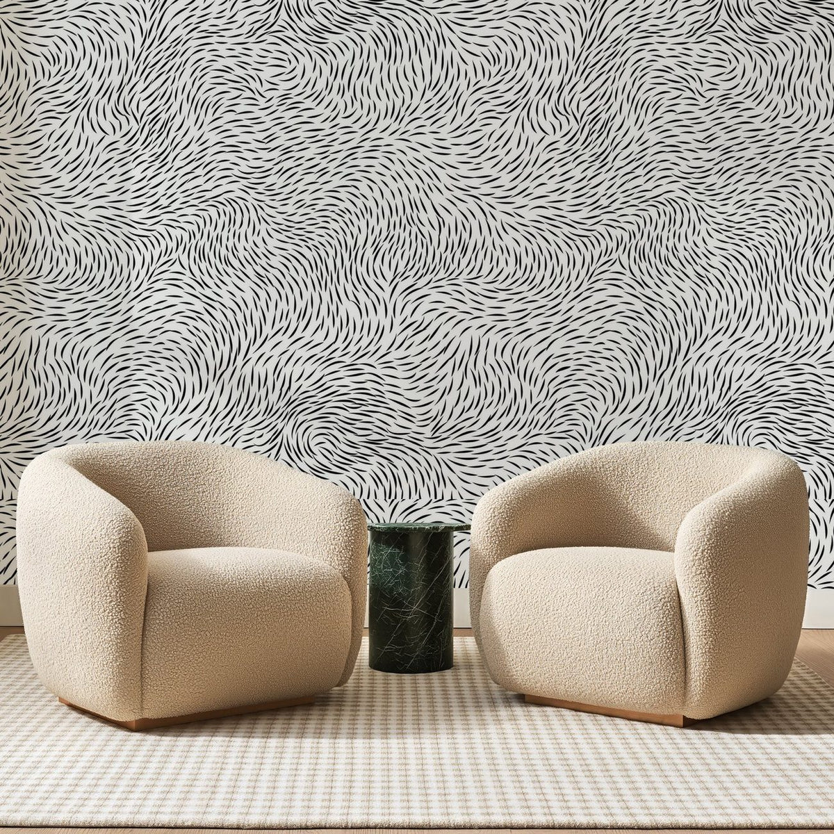 Papier peint panoramique Remous de Traits Noirs, posé sur toute la paroi d'un salon, derrière deux fauteuils en bouclette crème et un guéridon en marbre vert