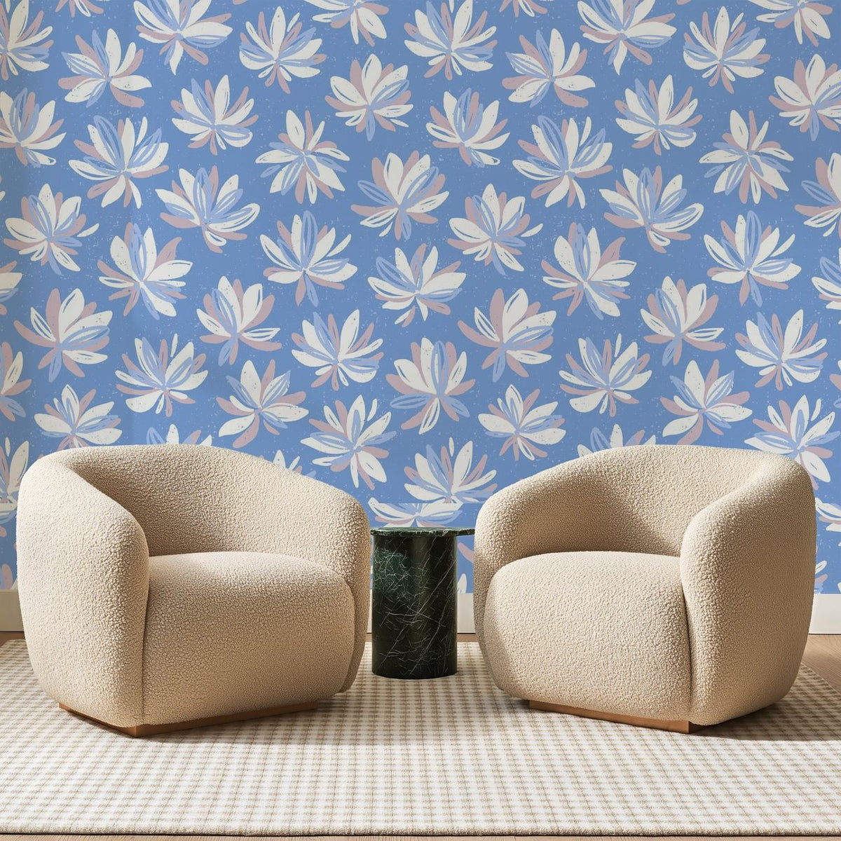 Papier peint panoramique Fleurs Étoilées sur Bleu Bleuet, posé sur toute la paroi d'un salon, derrière deux fauteuils en bouclette crème et un guéridon en marbre vert