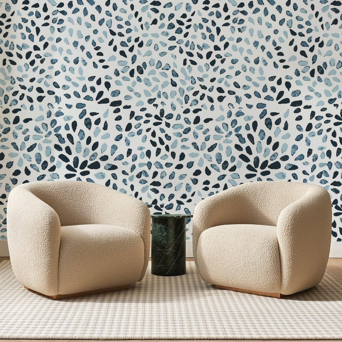 Papier peint panoramique Touches d'Aquarelle Bleu Indigo, posé sur toute la paroi d'un salon, derrière deux fauteuils en bouclette crème et un guéridon en marbre vert
