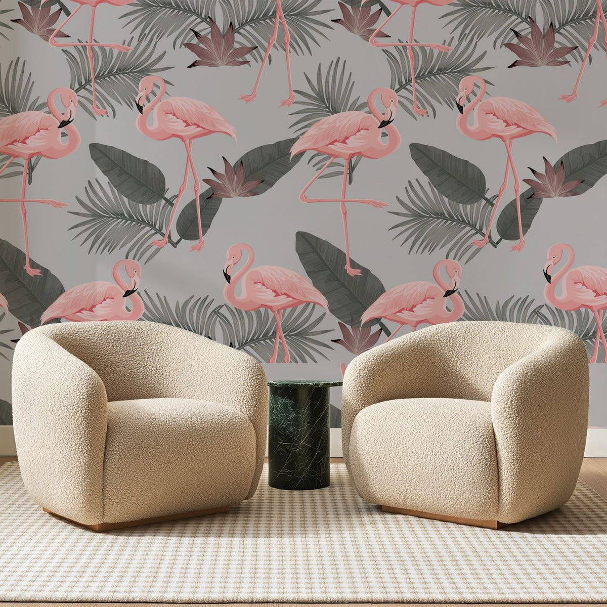 Papier peint panoramique Flamants Roses sur Gris Perle, posé sur toute la paroi d'un salon, derrière deux fauteuils en bouclette crème et un guéridon en marbre vert