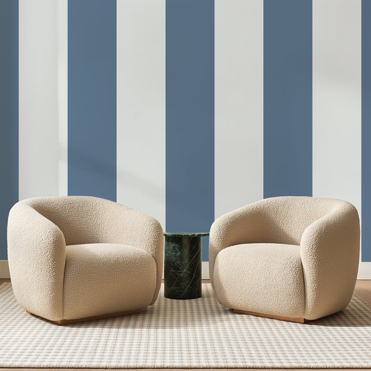 Papier peint panoramique Rayures Verticales Bleu Gris, posé sur toute la paroi d'un salon, derrière deux fauteuils en bouclette crème et un guéridon en marbre vert