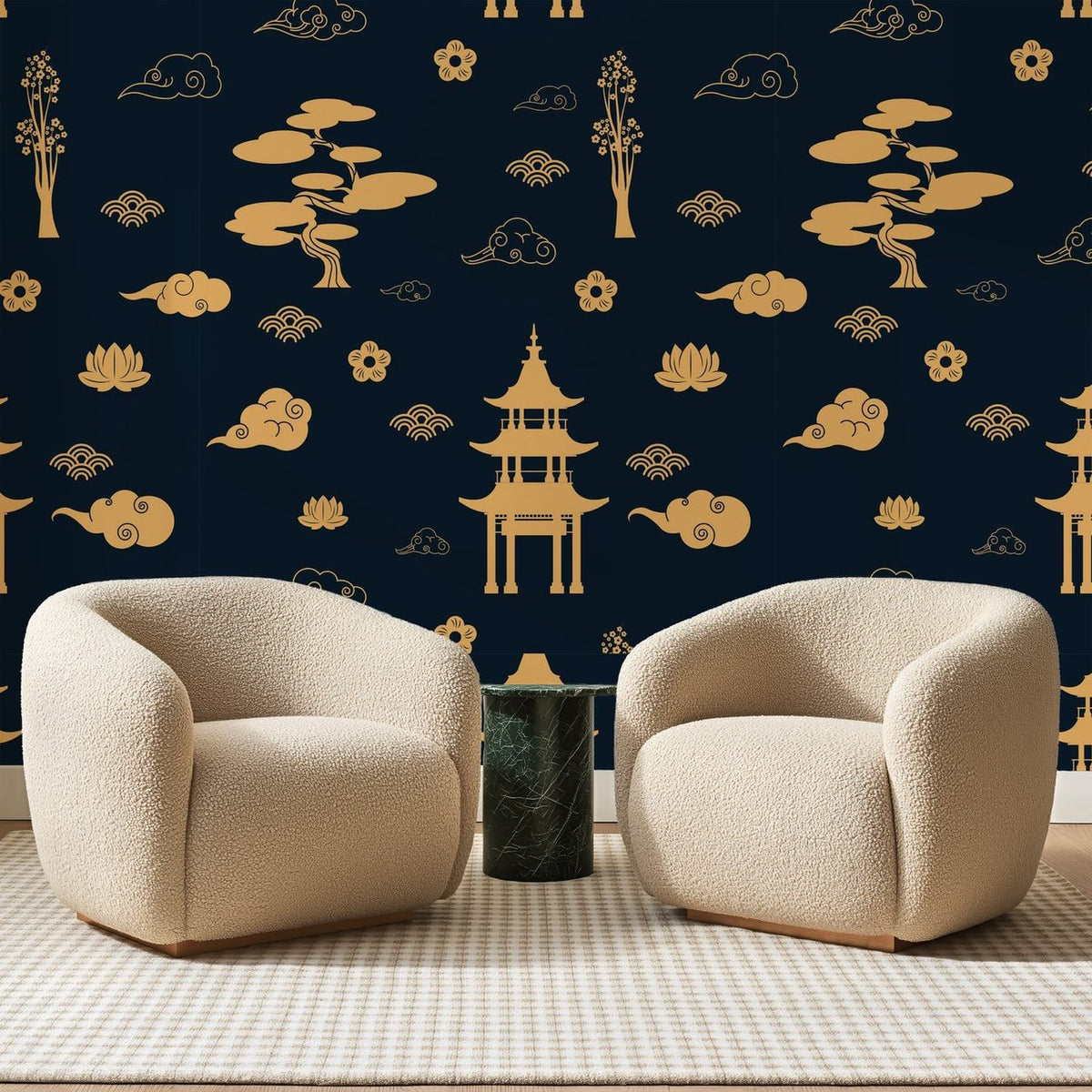 Papier peint panoramique Pagodes Dorées sur Bleu Nuit, posé sur toute la paroi d'un salon, derrière deux fauteuils en bouclette crème et un guéridon en marbre vert.