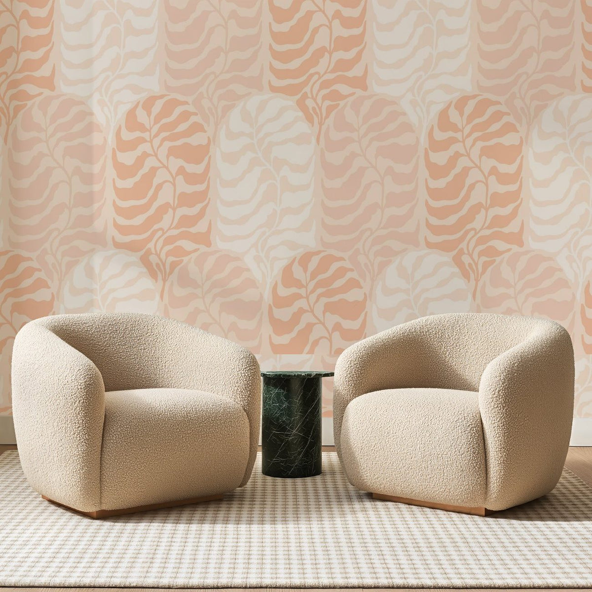 Papier peint panoramique Dômes Ondulés Rose Pêche, posé sur toute la paroi d'un salon, derrière deux fauteuils en bouclette crème et un guéridon en marbre vert