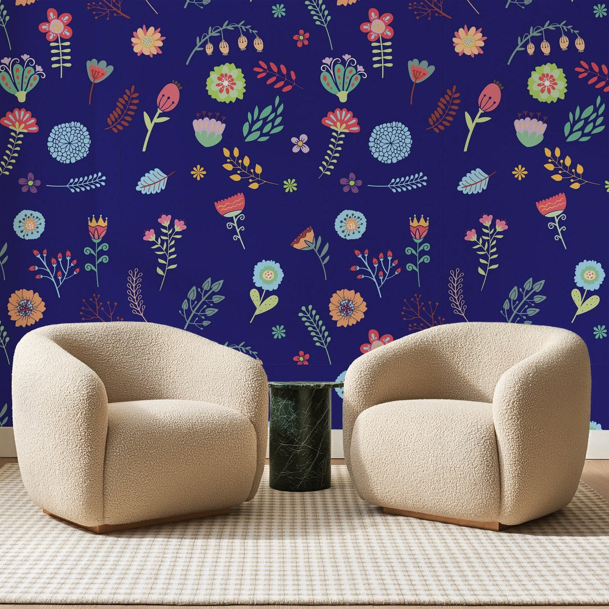 Papier peint panoramique Fleurettes Naïves Bleu Indigo, posé sur toute la paroi d'un salon, derrière deux fauteuils en bouclette crème et un guéridon en marbre vert
