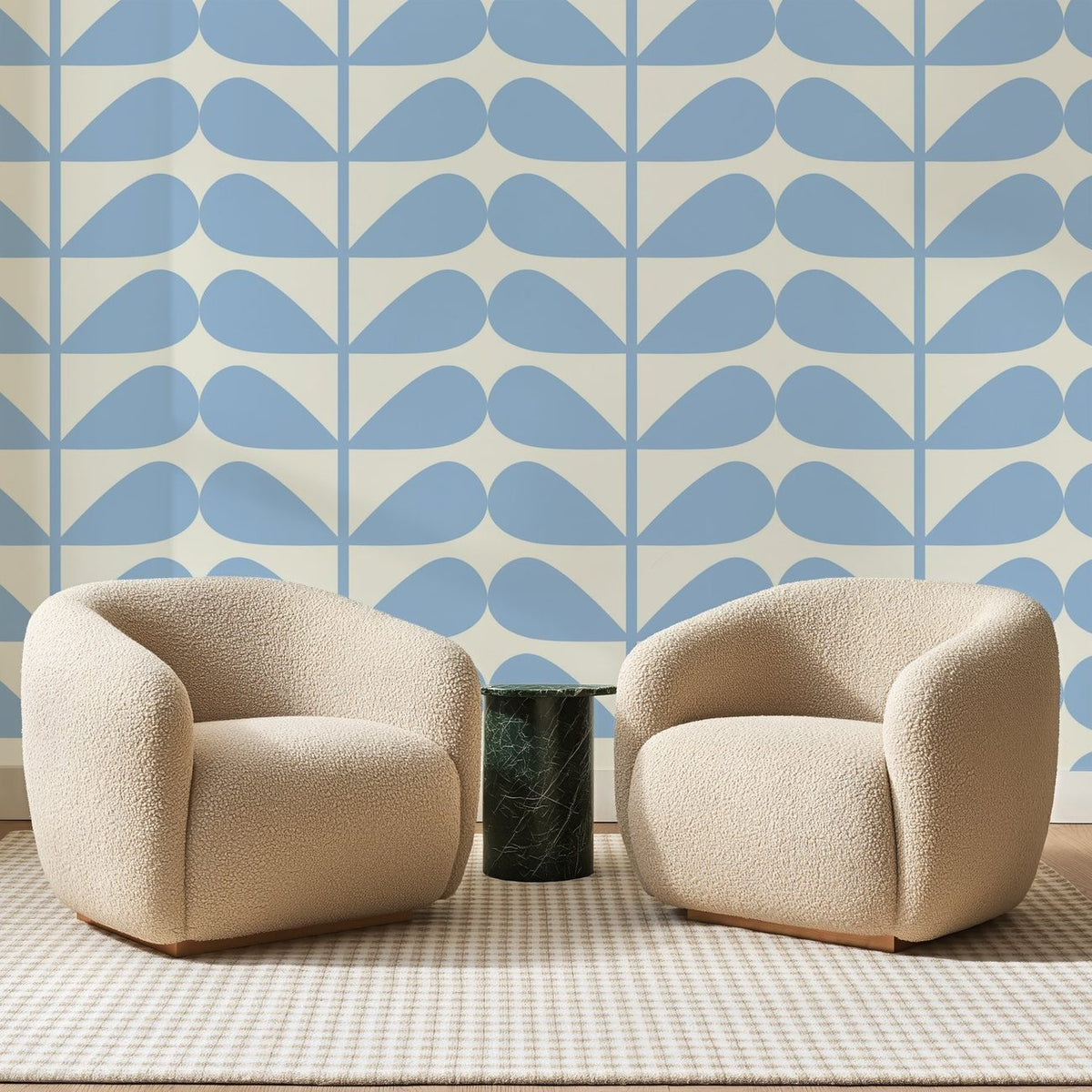 Papier peint panoramique Pétales Bleu Ciel sur Ivoire, posé sur toute la paroi d'un salon, derrière deux fauteuils en bouclette crème et un guéridon en marbre vert