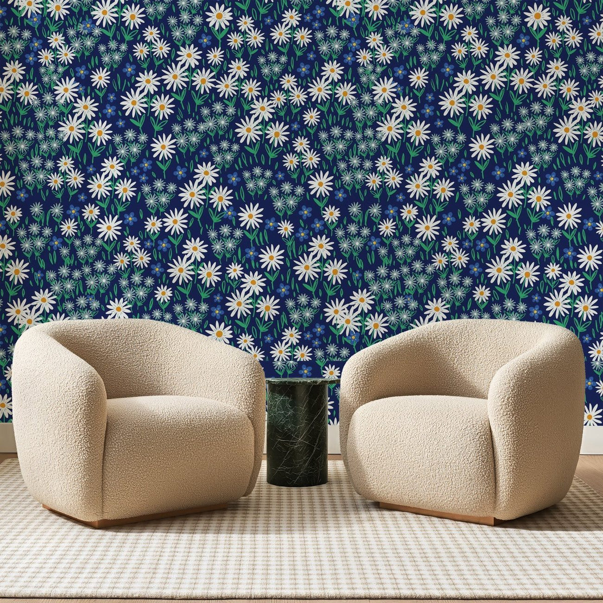 Papier peint panoramique Marguerites sur Bleu Marine, posé sur toute la paroi d'un salon, derrière deux fauteuils en bouclette crème et un guéridon en marbre vert