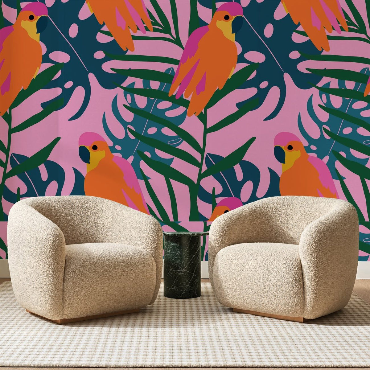 Papier peint panoramique Perroquets Orange sur Rose Vif, posé sur toute la paroi d'un salon, derrière deux fauteuils en bouclette crème et un guéridon en marbre vert
