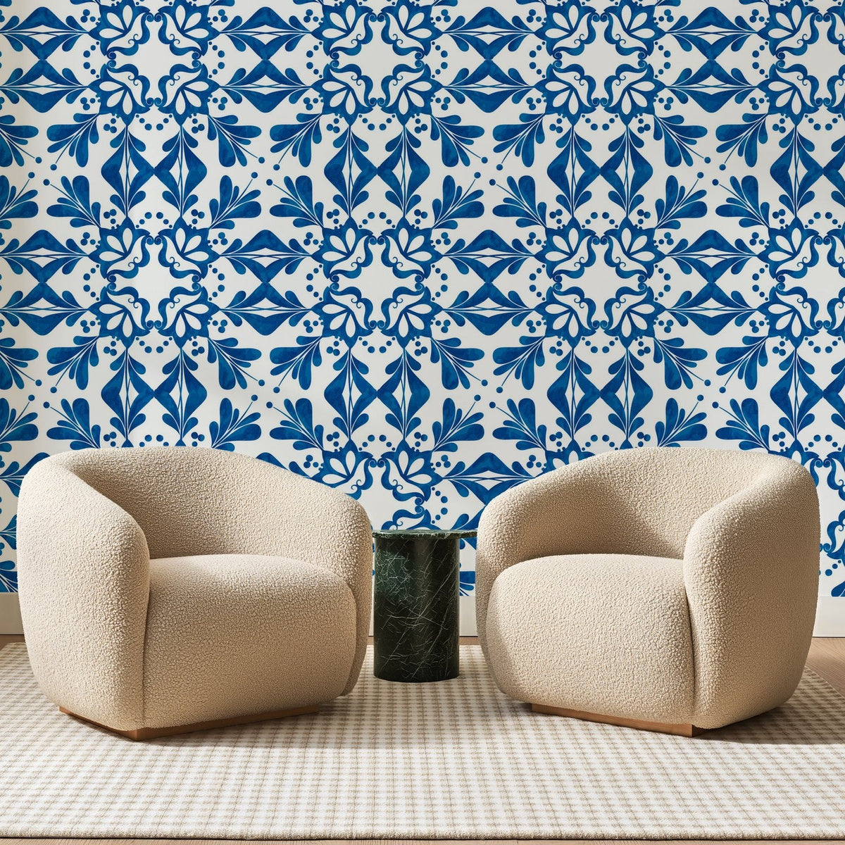 Papier peint panoramique Azulejos à Volutes Bleu Cobalt, posé sur toute la paroi d'un salon, derrière deux fauteuils en bouclette crème et un guéridon en marbre vert