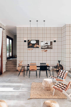 Séjour et salle à manger tapissés de l'écossais beige et blanc, suspensions noires et tapis en jute.