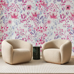 Papier peint panoramique Aquarelle Fleurie Rose et Lavande, posé sur toute la paroi d'un salon, derrière deux fauteuils en bouclette crème et un guéridon en marbre vert