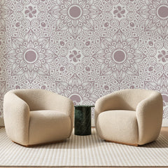 Papier peint panoramique Rosaces Étoilées Vieux Rose, posé sur toute la paroi d'un salon, derrière deux fauteuils en bouclette crème et un guéridon en marbre vert
