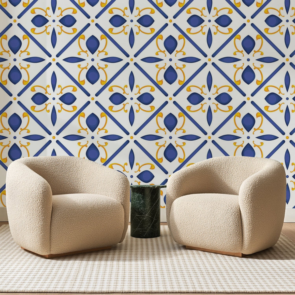 Papier peint panoramique Carreaux Fleuris Bleu et Safran, posé sur toute la paroi d'un salon, derrière deux fauteuils en bouclette crème et un guéridon en marbre vert