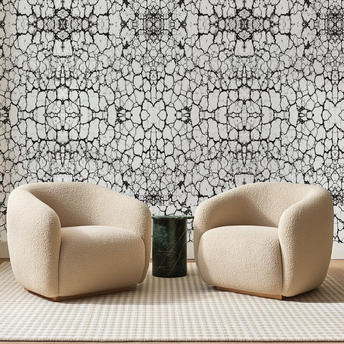 Papier peint panoramique Craquelures Noires sur Blanc, posé sur toute la paroi d'un salon, derrière deux fauteuils en bouclette crème et un guéridon en marbre vert
