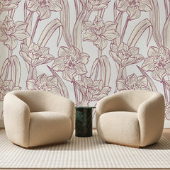 Papier peint panoramique Jonquilles au Trait Lie-de-Vin, posé sur toute la paroi d'un salon, derrière deux fauteuils en bouclette crème et un guéridon en marbre vert