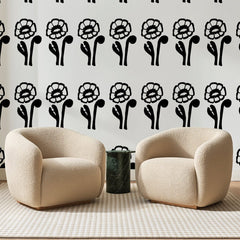Papier peint panoramique Fleurs à l'Encre Noire, posé sur toute la paroi d'un salon, derrière deux fauteuils en bouclette crème et un guéridon en marbre vert
