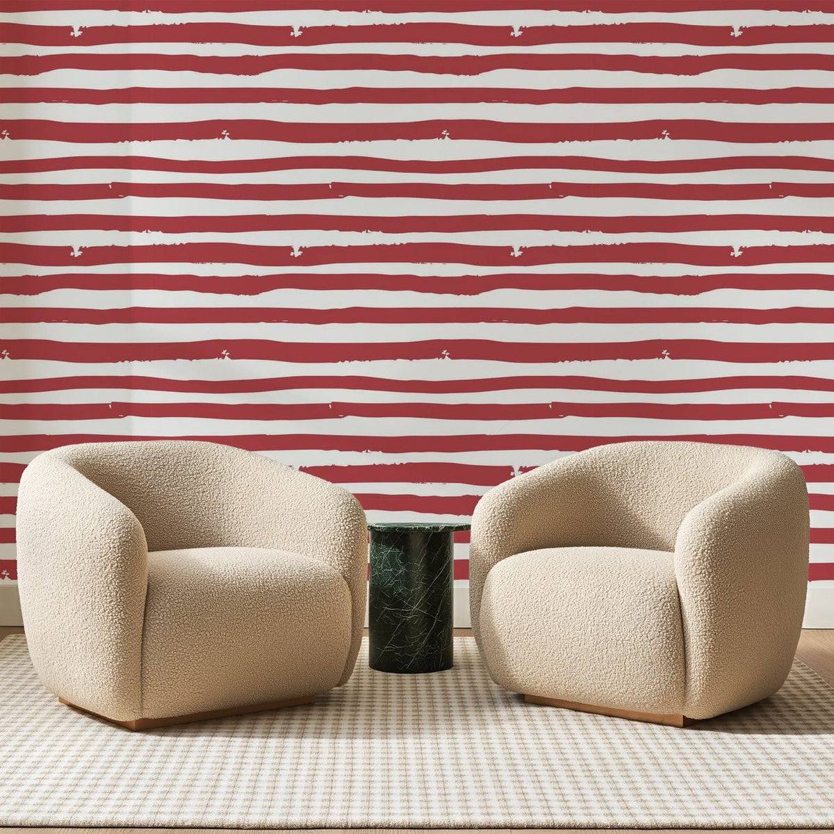 Papier peint panoramique Bandes Peintes Rouge Brique, posé sur toute la paroi d'un salon, derrière deux fauteuils en bouclette crème et un guéridon en marbre vert