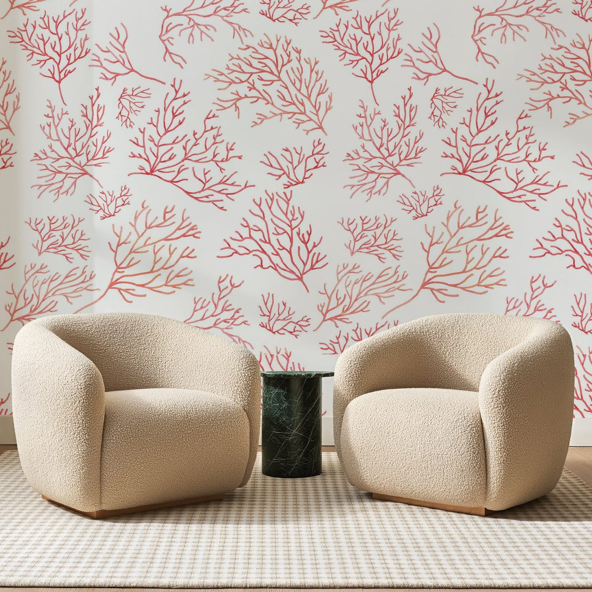 Papier peint panoramique Branches de Corail Rose, posé sur toute la paroi d'un salon, derrière deux fauteuils en bouclette crème et un guéridon en marbre vert