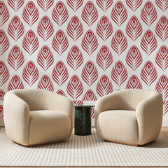 Papier peint panoramique Ocelles de Paon Rouge Brique, posé sur toute la paroi d'un salon, derrière deux fauteuils en bouclette crème et un guéridon en marbre vert