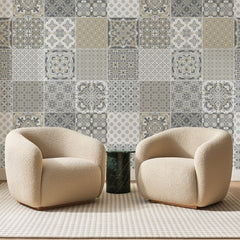 Papier peint panoramique Patchwork de Carreaux Gris et Sable, posé sur toute la paroi d'un salon, derrière deux fauteuils en bouclette crème et un guéridon en marbre vert