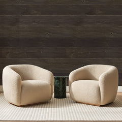 Papier peint panoramique Lames de Bois Brun Sombre, posé sur toute la paroi d'un salon, derrière deux fauteuils en bouclette crème et un guéridon en marbre vert