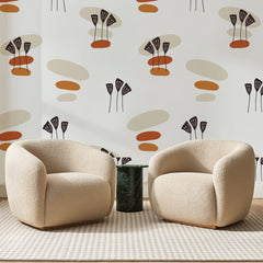 Papier peint panoramique Galets et Ombelles Terracotta, posé sur toute la paroi d'un salon, derrière deux fauteuils en bouclette crème et un guéridon en marbre vert