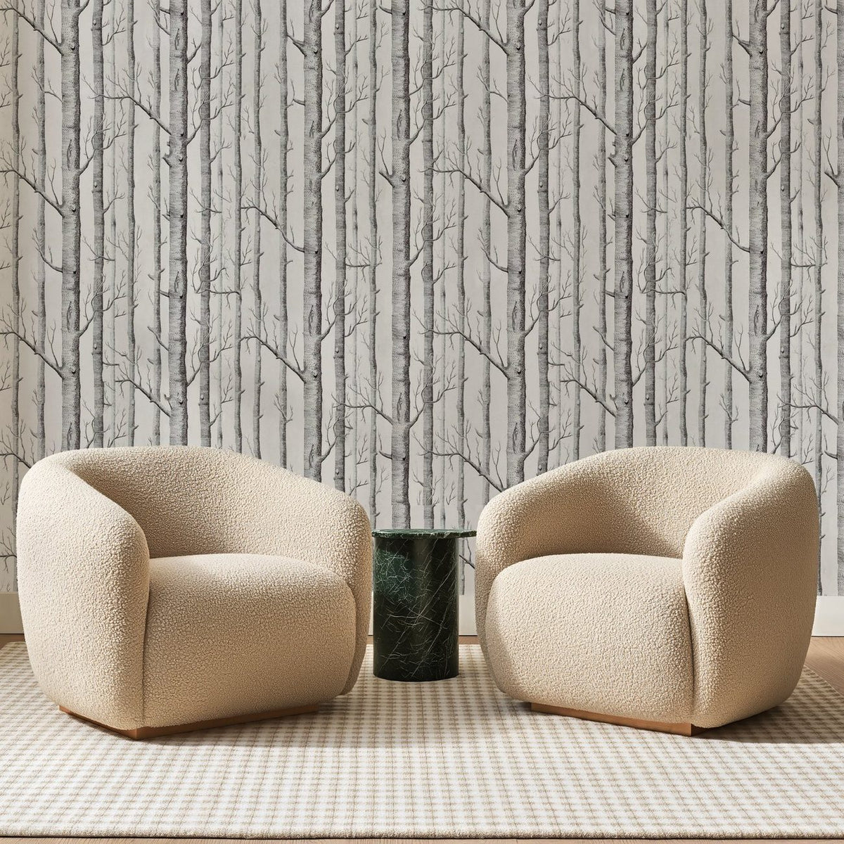 Papier peint panoramique Bouleaux Serrés Gris Clair, posé sur toute la paroi d'un salon, derrière deux fauteuils en bouclette crème et un guéridon en marbre vert