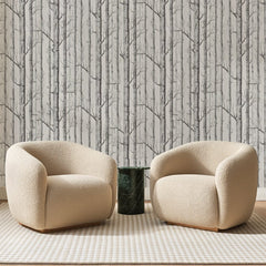 Papier peint panoramique Bouleaux Serrés Gris Clair, posé sur toute la paroi d'un salon, derrière deux fauteuils en bouclette crème et un guéridon en marbre vert