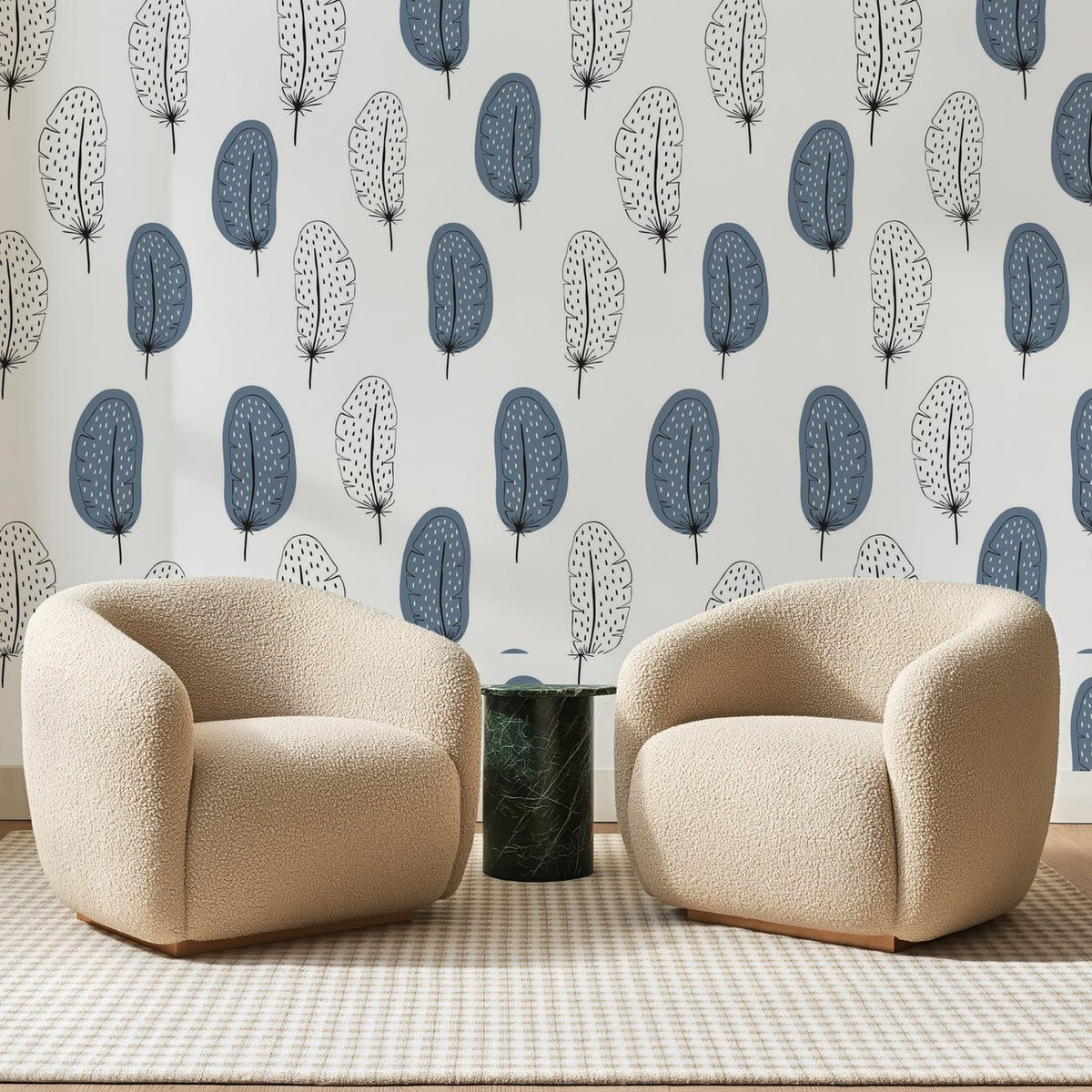 Papier peint panoramique Plumes Scandinaves Bleu Ardoise, posé sur toute la paroi d'un salon, derrière deux fauteuils en bouclette crème et un guéridon en marbre vert