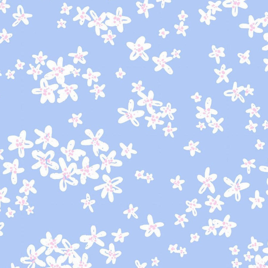 Gros plan de l'impression : fleurette blanche au contour tracé main, cœur ponctué de points rose bonbon et fin trait bleu sur les pétales.
