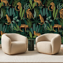 Papier peint panoramique Léopards en Jungle Sombre, posé sur toute la paroi d'un salon, derrière deux fauteuils en bouclette crème et un guéridon en marbre vert
