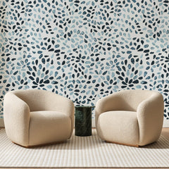 Papier peint panoramique Touches d'Aquarelle Bleu Indigo, posé sur toute la paroi d'un salon, derrière deux fauteuils en bouclette crème et un guéridon en marbre vert