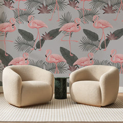 Papier peint panoramique Flamants Roses sur Gris Perle, posé sur toute la paroi d'un salon, derrière deux fauteuils en bouclette crème et un guéridon en marbre vert
