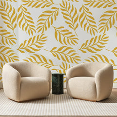 Papier peint panoramique Rameaux Jaune Safran, posé sur toute la paroi d'un salon, derrière deux fauteuils en bouclette crème et un guéridon en marbre vert