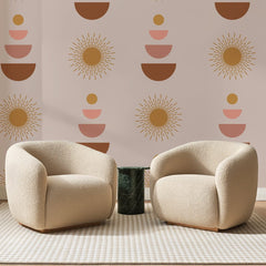 Papier peint panoramique Soleils Ocre sur Rose Poudré, posé sur toute la paroi d'un salon, derrière deux fauteuils en bouclette crème et un guéridon en marbre vert