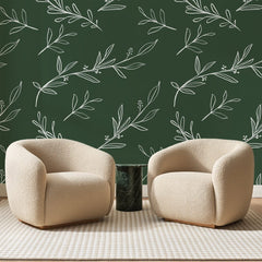 Papier peint panoramique Brindilles Blanches sur Vert Forêt, posé sur toute la paroi d'un salon, derrière deux fauteuils en bouclette crème et un guéridon en marbre vert