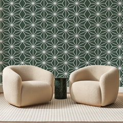 Papier peint panoramique Trame d'Étoiles Vert Sauge, posé sur toute la paroi d'un salon, derrière deux fauteuils en bouclette crème et un guéridon en marbre vert