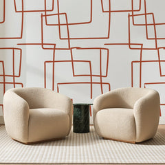 Papier peint panoramique Carrés au Trait Terracotta, posé sur toute la paroi d'un salon, derrière deux fauteuils en bouclette crème et un guéridon en marbre vert