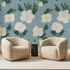 Papier peint panoramique Fleurs au Pinceau Bleu Gris, posé sur toute la paroi d'un salon, derrière deux fauteuils en bouclette crème et un guéridon en marbre vert