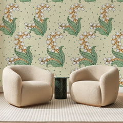 Papier peint panoramique Muguet Blanc sur Crème, posé sur toute la paroi d'un salon, derrière deux fauteuils en bouclette crème et un guéridon en marbre vert