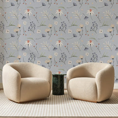 Papier peint panoramique Semis Fleuri sur Gris Perle, posé sur toute la paroi d'un salon, derrière deux fauteuils en bouclette crème et un guéridon en marbre vert