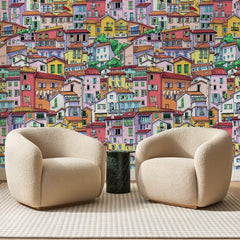 Papier peint panoramique Village Italien Toits Terracotta, posé sur toute la paroi d'un salon, derrière deux fauteuils en bouclette crème et un guéridon en marbre vert