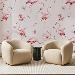 Papier peint panoramique Flamants à l'Aquarelle Rose Poudré, posé sur toute la paroi d'un salon, derrière deux fauteuils en bouclette crème et un guéridon en marbre vert