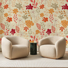 Papier peint panoramique Jardin d'Automne Rouge et Ocre, posé sur toute la paroi d'un salon, derrière deux fauteuils en bouclette crème et un guéridon en marbre vert.