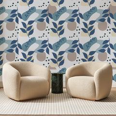Papier peint panoramique Collage Végétal Bleu Pastel, posé sur toute la paroi d'un salon, derrière deux fauteuils en bouclette crème et un guéridon en marbre vert