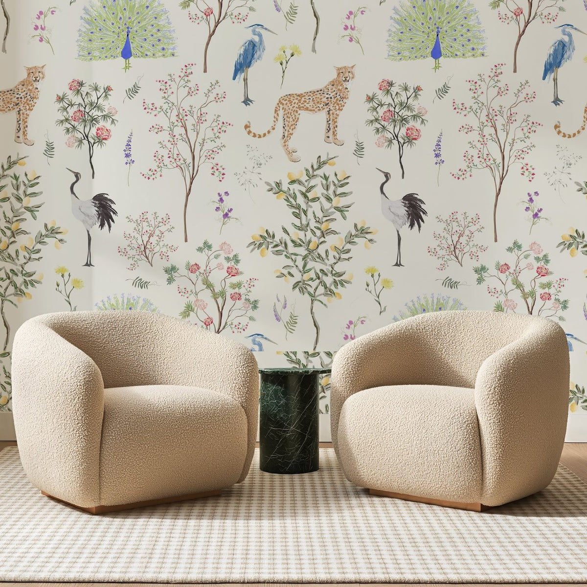 Papier peint panoramique Ménagerie Aquarelle Ivoire, posé sur toute la paroi d'un salon, derrière deux fauteuils en bouclette crème et un guéridon en marbre vert