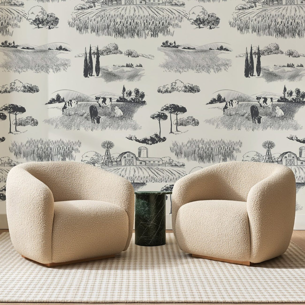 Papier peint panoramique Campagne à l'Encre Noire, posé sur toute la paroi d'un salon, derrière deux fauteuils en bouclette crème et un guéridon en marbre vert.