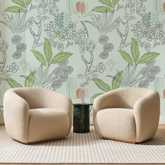 Papier peint panoramique Cactus au Trait Vert Menthe, posé sur toute la paroi d'un salon, derrière deux fauteuils en bouclette crème et un guéridon en marbre vert
