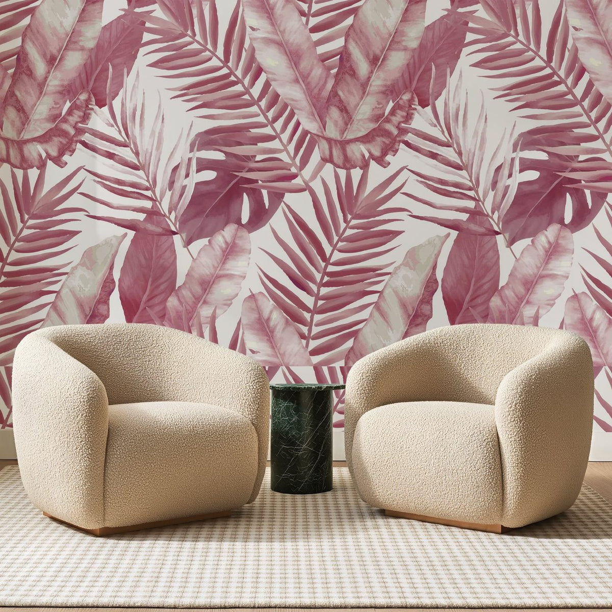 Papier peint panoramique Palmes Tropicales Rose Aquarelle, posé sur toute la paroi d'un salon, derrière deux fauteuils en bouclette crème et un guéridon en marbre vert.