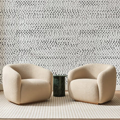 Papier peint panoramique Semis de Pois Gris, posé sur toute la paroi d'un salon, derrière deux fauteuils en bouclette crème et un guéridon en marbre vert