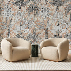 Papier peint panoramique Palmeraie Gravée Abricot, posé sur toute la paroi d'un salon, derrière deux fauteuils en bouclette crème et un guéridon en marbre vert